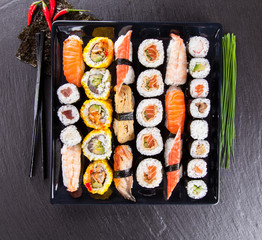 Sushi pieces on black stone