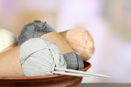 Knitting yarn with knitting needles, on light background