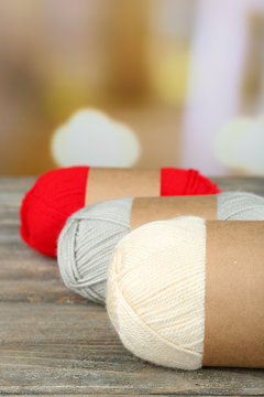 Knitting yarn on wooden table, on light background