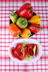 Pepper on oval and round plate on fabric background