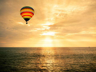 Fototapeta premium Hot air balloon over the sea at sunset