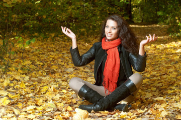 Woman in red scarf sits cross-legged and raising his hands