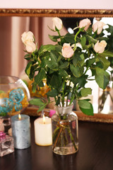 Beautiful vase with roses near mirror