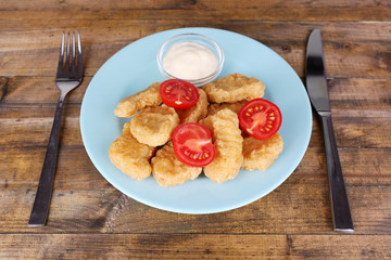 Chicken nuggets with sauce on table close-up