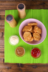 Chicken nuggets with sauces on table close-up