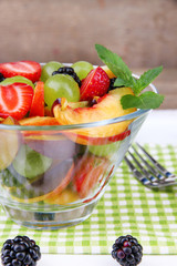 fresh tasty fruit salad on wooden table