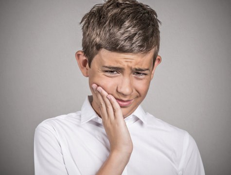 Headshot young man with sensitive tooth ache grey background 