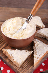 Fresh homemade butter in bowl and sliced bread,
