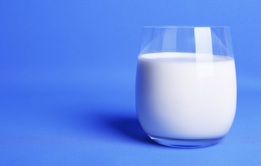 Milk in glass on blue background