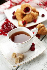 Breakfast with tea, jam and fresh croissants