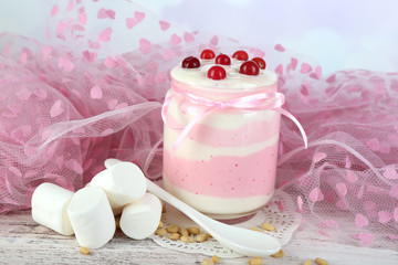 Raspberry milk dessert in glass jar,