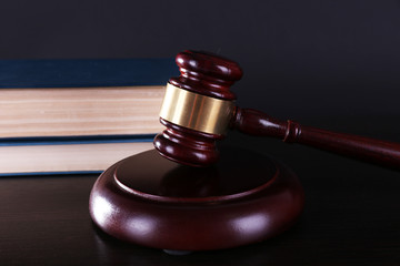 Judge's gavel and books on dark grey background