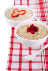 Tasty oatmeal with berries on napkin close-up