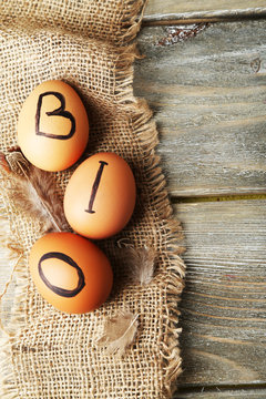Eggs with inscription BIO on eggshell, on wooden background