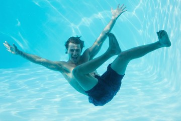 Young man swimming underwater - Powered by Adobe