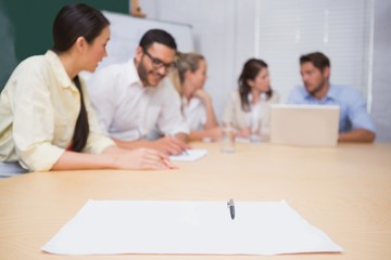 Blank page on the table in front of the business team