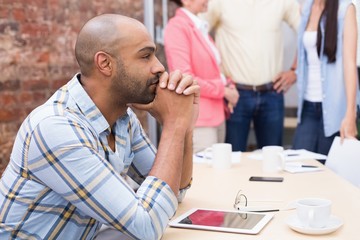 Focused man sitting at desk using his tablet