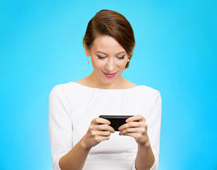 smiling woman texting on smartphone on blue background 