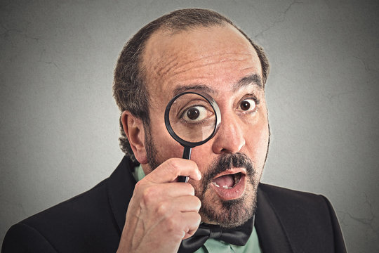 investigator man looking with magnifying glass surprised face