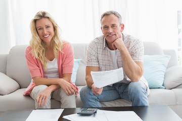 Couple doing their accounts sat in a couch