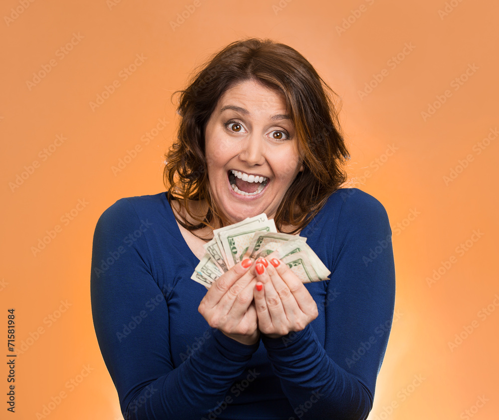 Wall mural excited business woman holding money on orange background 