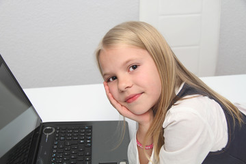 Little girl with her laptop at home