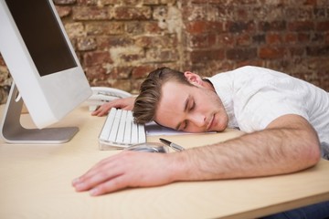 Casual man sleeping at his desk