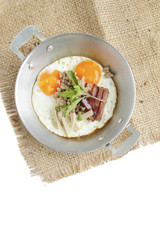 Healthy breakfast - fried eggs, ham, bacon, pork in the pan and