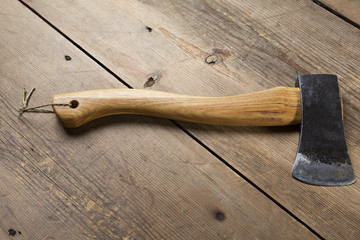 Wooden handle axe lying on wooden table