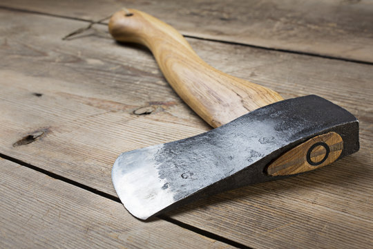 Wooden handle axe lying on wooden table