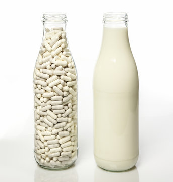 Milchflasche daneben Milchflasche mit Laktasekapseln