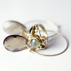 Golden ring and earrings against white background