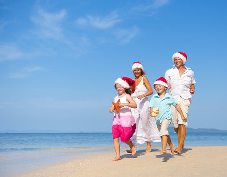 Family Having Fun On The Beach On Christmas