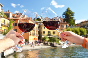 Two wineglasses in the hands. Varenna town at the lake Como, Ita - 71586331