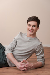 young casual man sitting and smiling to the camera.