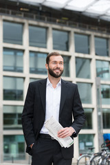 erfolgreicher geschäftsmann vor dem bürogebäude