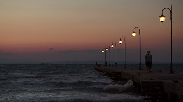 People walking and stading on pier in the evening