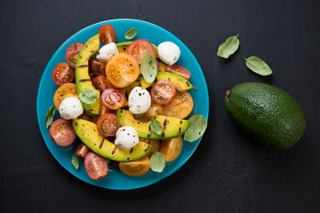Salad with grilled avocado, tomatoes and mozzarella cheese