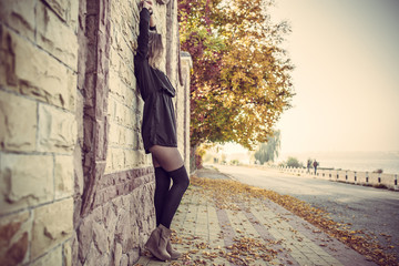 Young pretty elegant lady posing near urban light wall at vintag