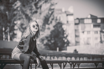 Obraz na płótnie Canvas Young pretty girl sitting on bench in park