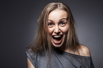 Angry woman screaming over dark grey