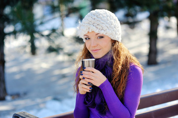 Winter girl drinking warm beverage