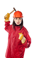 Crazy young helmeted woman worker holding a hammer
