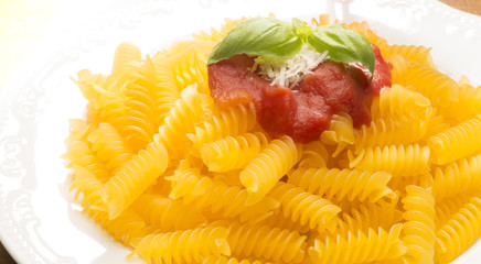 dish with macaroni and tomato sauce on the wooden table