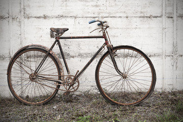 Naklejka na ściany i meble Antique or retro oxidized bicycle outside on a concrete wall