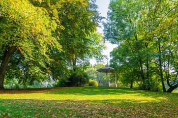 an old gazebo in a sunlit park in autumn