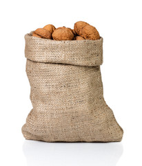 Walnuts in burlap bag on white