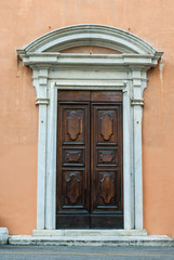 Portone di legno con fontone timpano e decorazioni