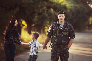 Family and soldier in a military uniform say goodbye
