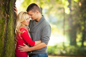 Young couple embracing on a sunny autumn day in nature